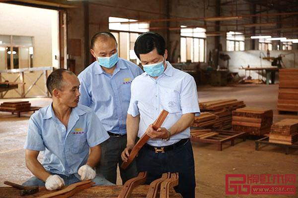 中国传统工艺大师、东成红木董事长张锡复（右一）到车间监督、指导产品工艺