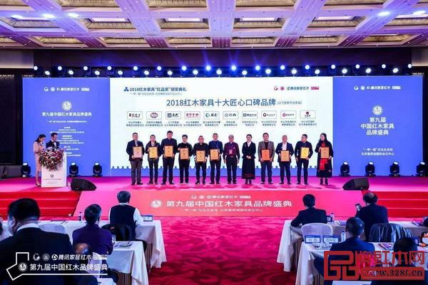 中国收藏家协会副会长维佳（右五）、亚太地区手工艺大师冯文土（右六）为“2018红木家具十大匠心口碑品牌”获奖企业颁奖，分别为华厦·大不同、古森红木、雍博堂、恒达木业、居典红木、匠王红木、大清御品、名扬红木、红宝轩、龙博士