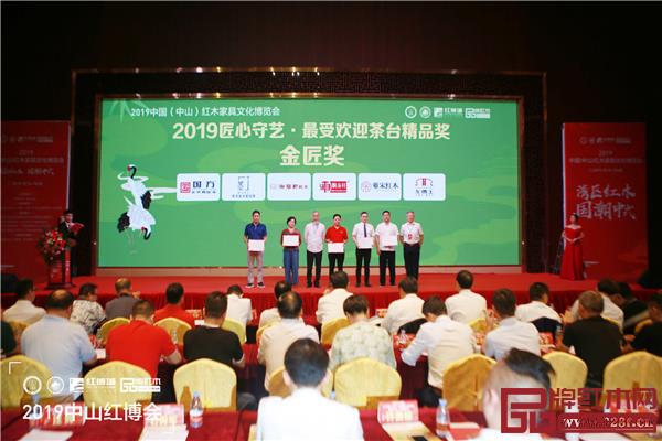 全联艺术红木家具专业委员会专家顾问、中国明式家具研究所原所长濮安国（左三）和全联艺术红木家具专业委员会专家顾问、华南农业大学博士生导师李凯夫（右一）为“匠心守艺·最受欢迎茶台精品奖·金匠奖”获奖品牌颁奖