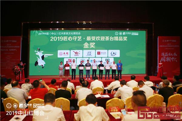 全联艺术红木家具专业委员会顾问、中国红木家具技术专家曹新民（右一）和全联艺术红木家具专业委员会专家顾问、华南农业大学研究生导师郭琼（左一）为“匠心守艺·最受欢迎茶台精品奖·金奖”获奖品牌颁奖