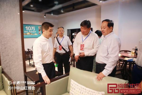 中国林业产业联合会副会长宋维明（左三），中山市大涌镇镇长贺修虎（右四）与忆古轩董事长刘定杰（左四）交流产品创新