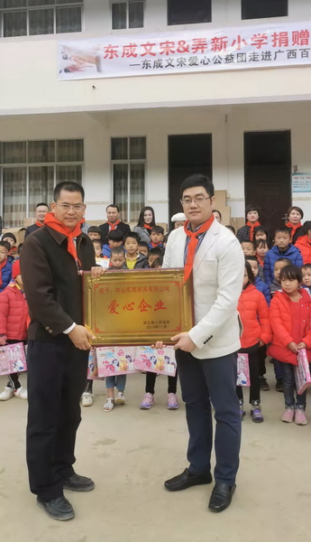 广西自治区党委组织部挂任凌云县委常委、副县长邱海富（左）为东成红木颁发牌匾，东成红木营销总经理曾东阳（右）代表企业接受授牌