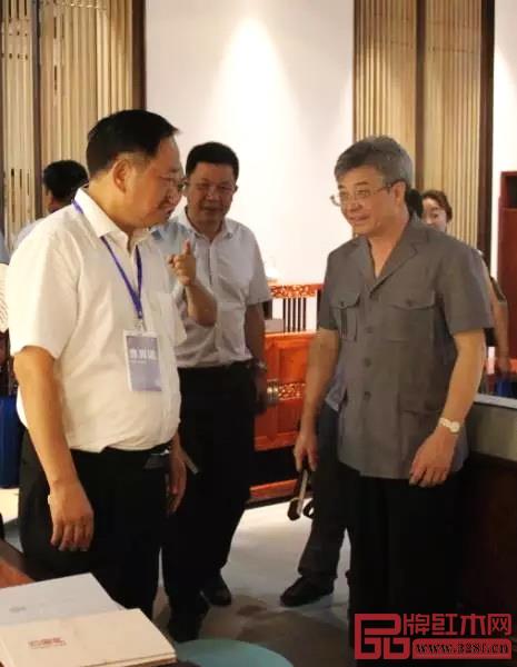 在首届中国新中式红木家具大会上,中山市政协主席丘树宏(右一)视察忆古轩展厅并与刘定杰(左一)亲切交流 在首届中国新中式红木家具大会上,中山市政协主席丘树宏(右一)视察忆古轩展厅并与刘定杰(左一)亲切交流