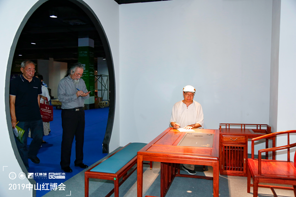 专家评审——中国明式家具研究所原所长濮安国(左二)、中国红木家具技术专家曹新民(左一)、教育部教学改革示范专业“家具设计与制造”专业带头人彭亮(右一)在为《尚贤茶台》现场打分,并给予了极高的评价 专家评审——中国明式家具研究所原所长濮安国(左二)、中国红木家具技术专家曹新民(左一)、教育部教学改革示范专业“家具设计与制造”专业带头人彭亮(右一)在为《尚贤茶台》现场打分,并给予了极高的评价