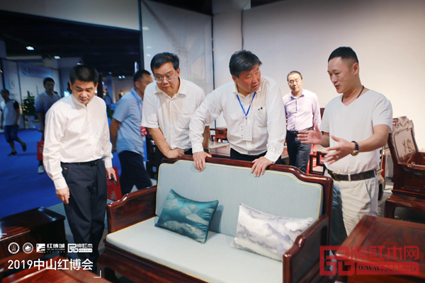 古木印象董事长周洪根(右一)向前来参观的领导、专家介绍古木印象产品的工艺及设计理念 古木印象董事长周洪根(右一)向前来参观的领导、专家介绍古木印象产品的工艺及设计理念