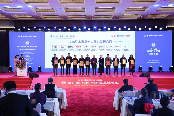 中国收藏家协会副会长维佳（右五）、亚太地区手工艺大师冯文土（右六）为“2018红木家具十大匠心口碑品牌”获奖企业颁奖，分别为华厦·大不同、古森红木、雍博堂、恒达木业、居典红木、匠王红木、大清御品、名扬红木、红宝轩、龙博士